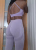 Kundin trägt ein lila Fitness-Set mit High-Waist Leggings und Sport-BH, perfekt für Yoga und Gym.