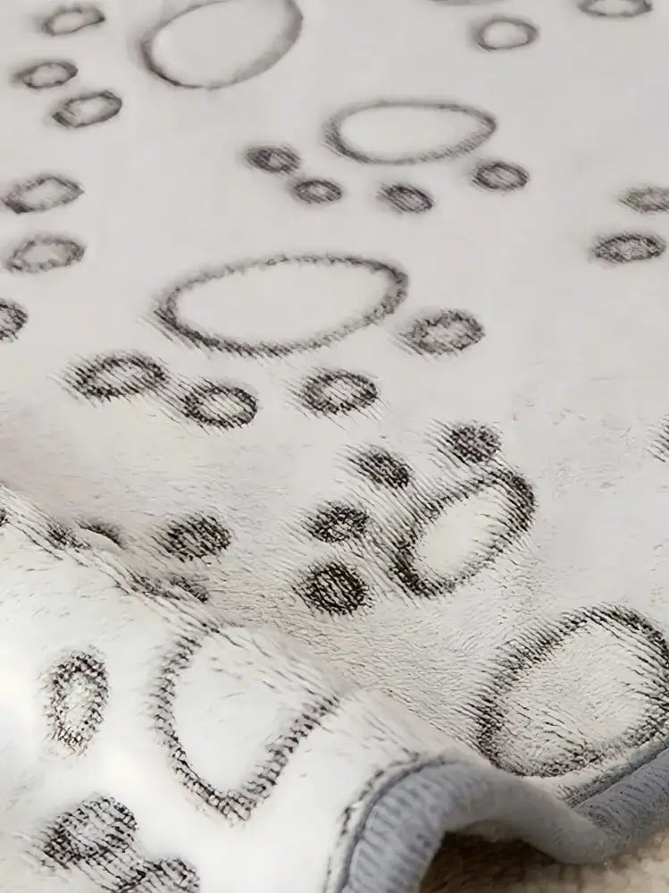 Detailansicht der weichen Haustierdecke mit Pfotenmuster und sauberer Kante