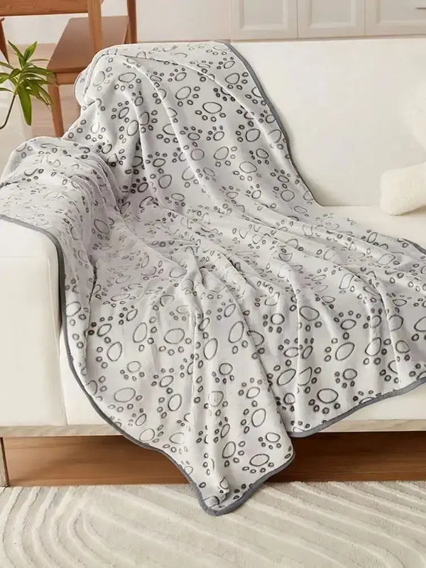 Haustierdecke mit Pfotenmuster auf dem Sofa für Hunde und Katzen
