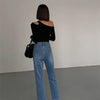 "Frau trägt schwarzes Dozw Streetwear-Top mit asymmetrischem Kragen und künstlerischen Cut-Out Details