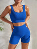 Frau in blauem 2-teiligem Ribbed Workout Set mit Crop Top und High Waist Shorts für Fitness und Yoga.